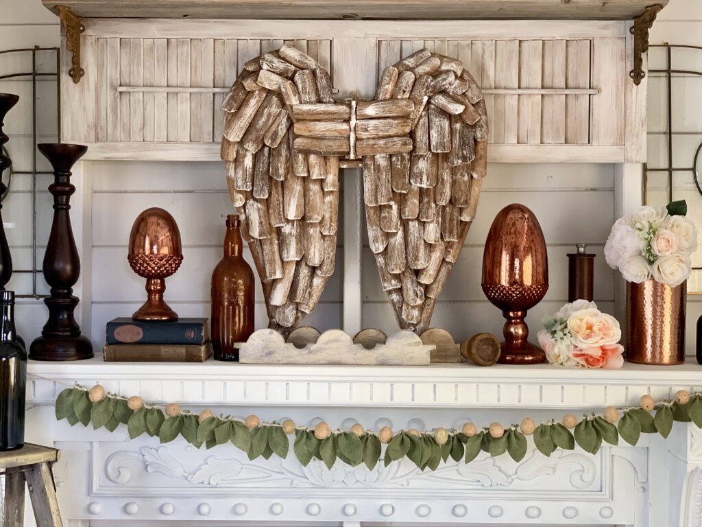 DIY felt leaf garland with speckled eggs displayed on a white mantel with farmhouse decor