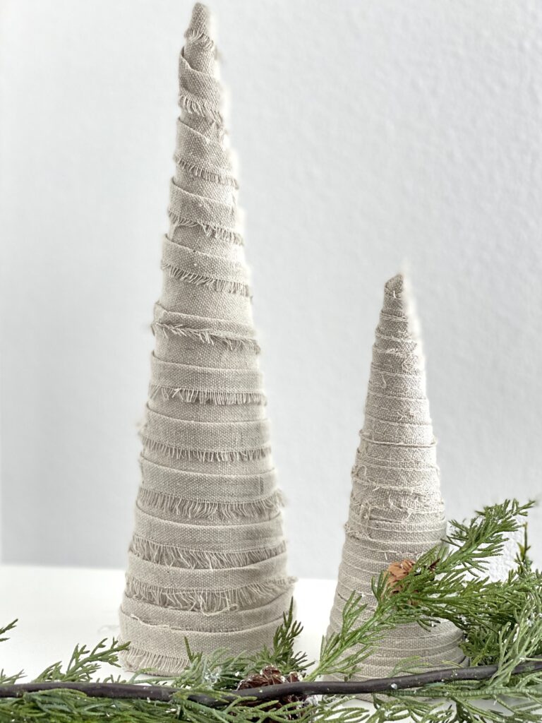 DIY Cone Christmas Trees Tutorial shown finished made with painter;s drop cloth.  Cone Christmas trees in two sizes