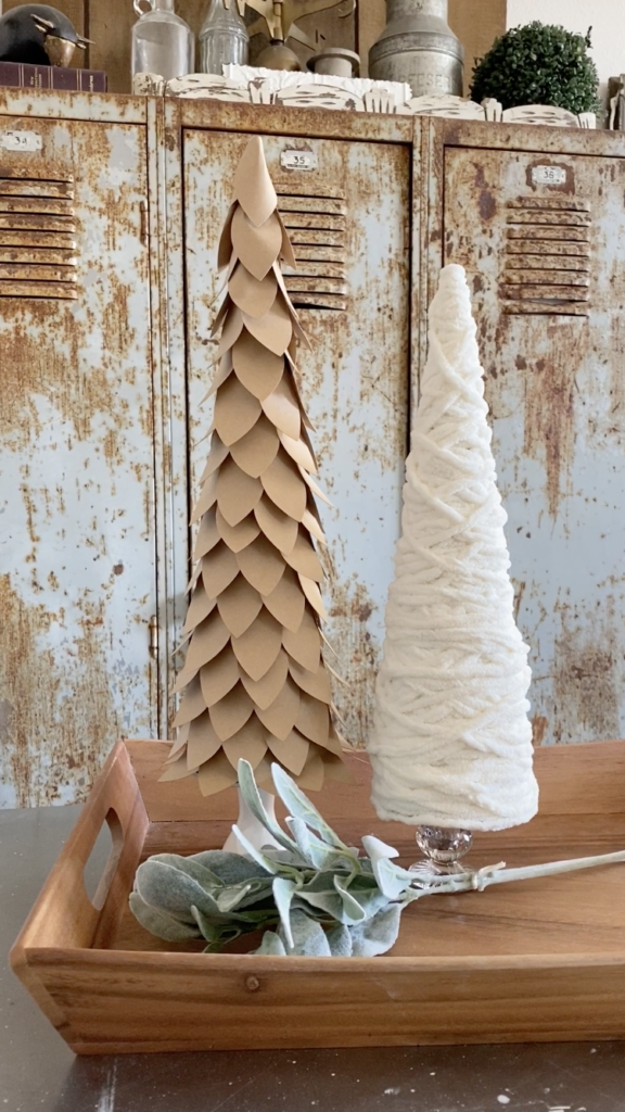 DIY Cone Christmas Trees made with yarn and paper displayed on a wood tray with lambs ear stem.