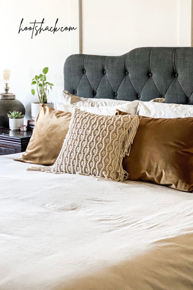 gray bed with neutral pillows