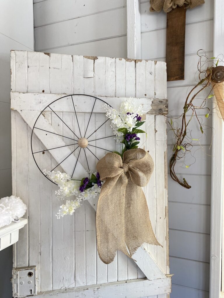 Dollar Tree Bicycle or wagon wheel wreath with white and purple flowers and a burlap bow