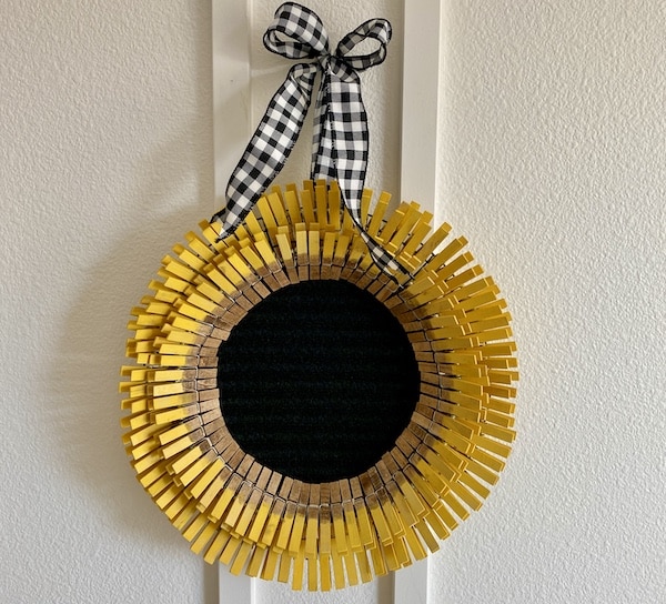 Clothespin Sunflower Wreath DIY hanging on a white wall