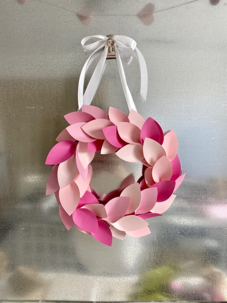 Pink paper leaf wreath hanging with white ribbon