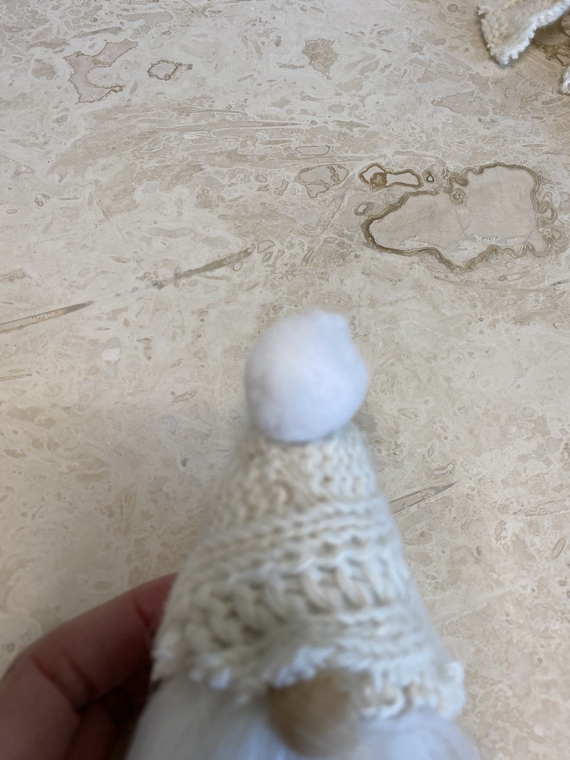 putting a pom pom on a gnome hat