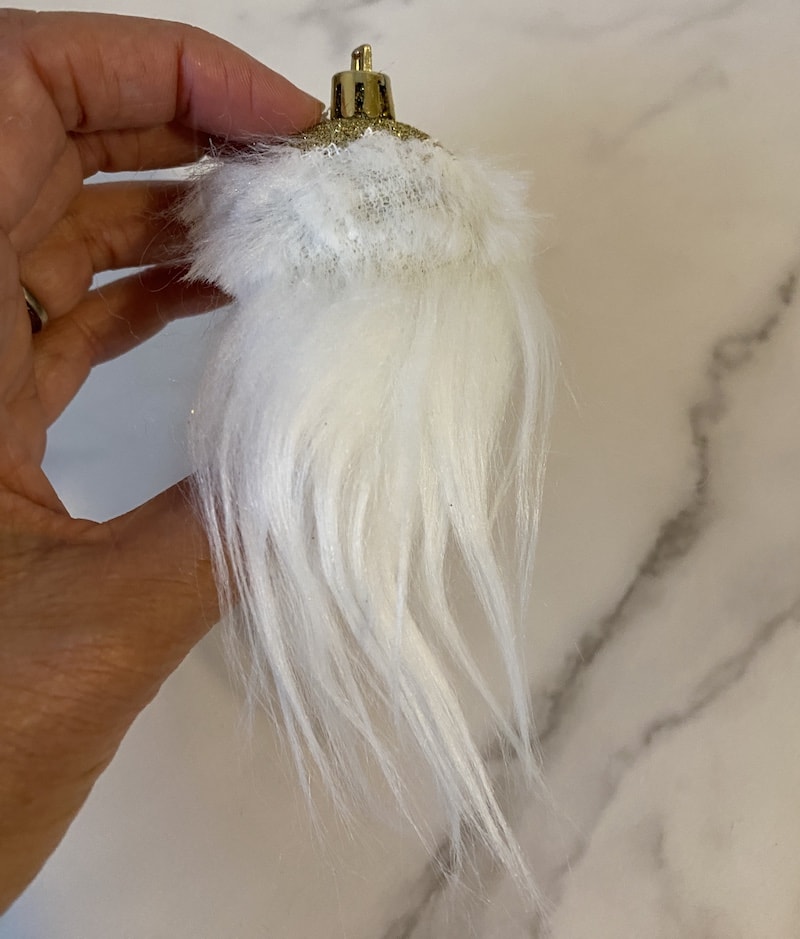glueing a gnome beard onto an ornament for a garland
