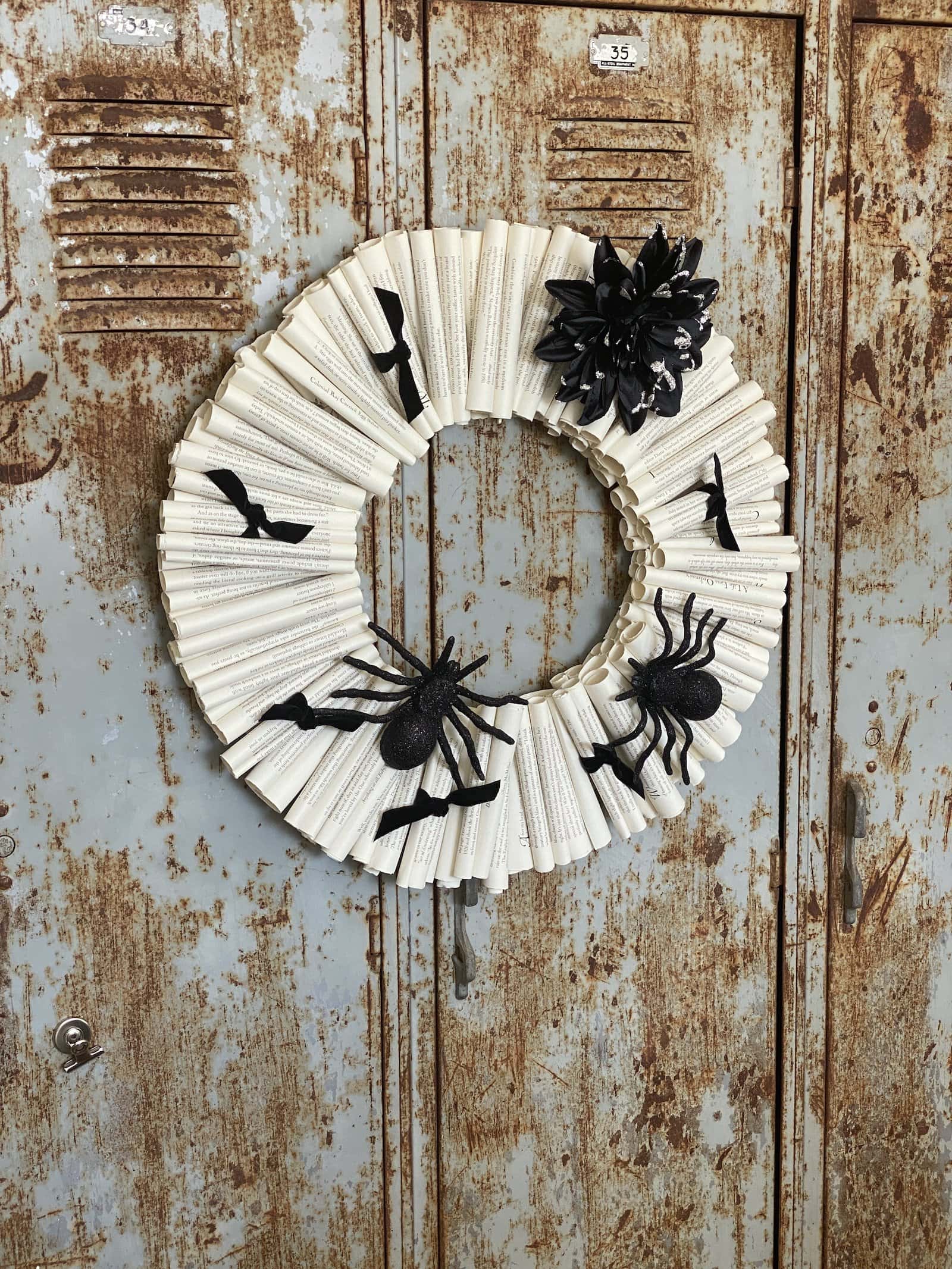 Book page Halloween wreath with spiders and a black flower