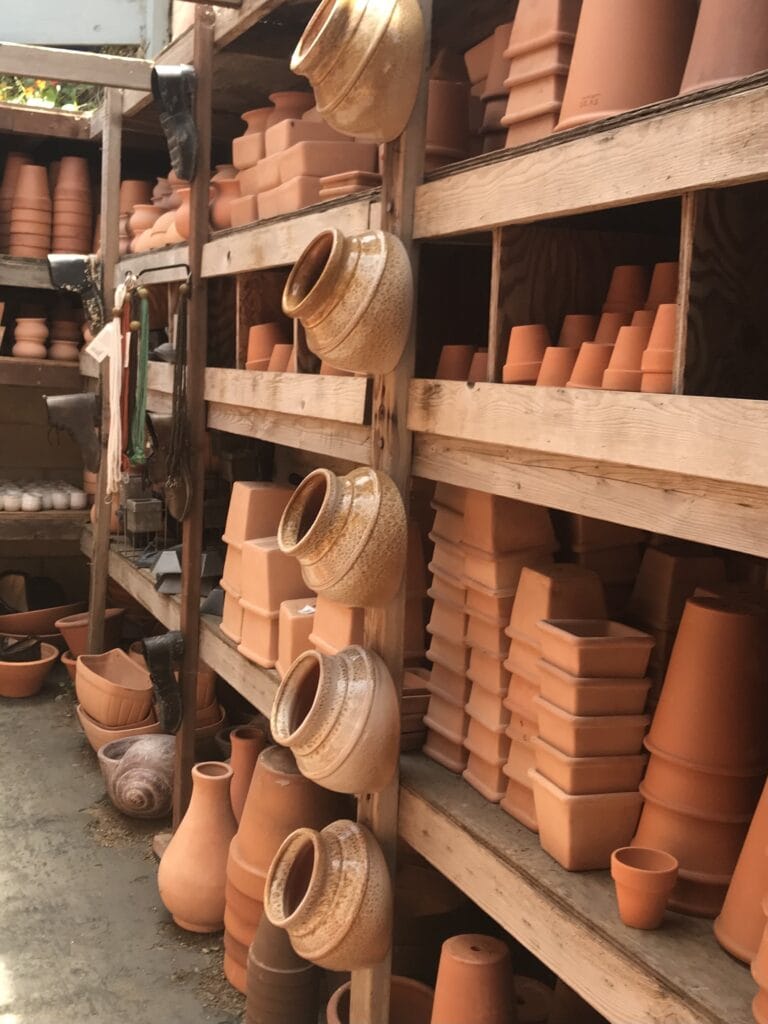 Terra cotta pots for succulents and plants stacked on shelves at a nursery